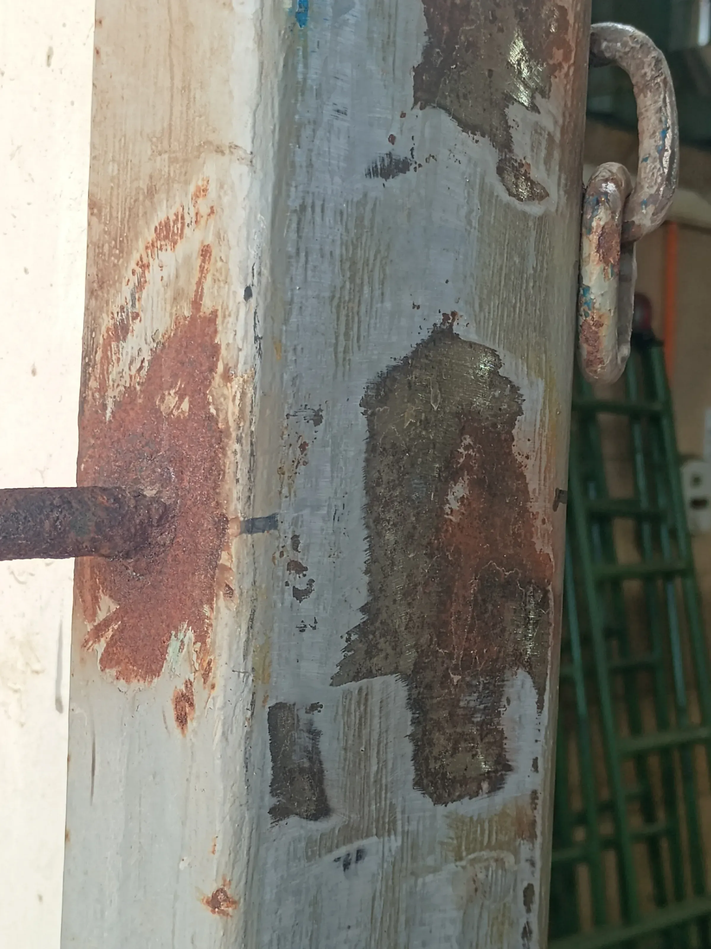 Estructura metálica industrial con corrosión severa, áreas de óxido expuesto y pintura desgastada, mostrando zonas lijadas previo a la aplicación de recubrimiento protector.