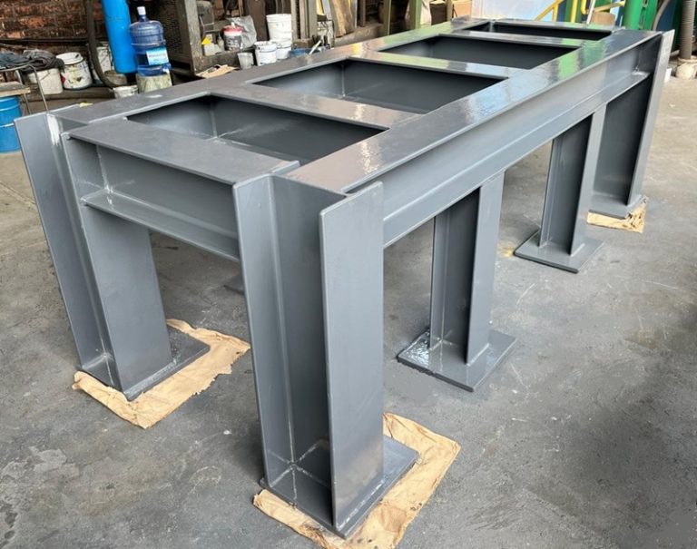 Estructura metálica de soporte fabricada con vigas de acero, recubierta con una capa polimérica gris brillante para protección anticorrosiva en taller industrial.
